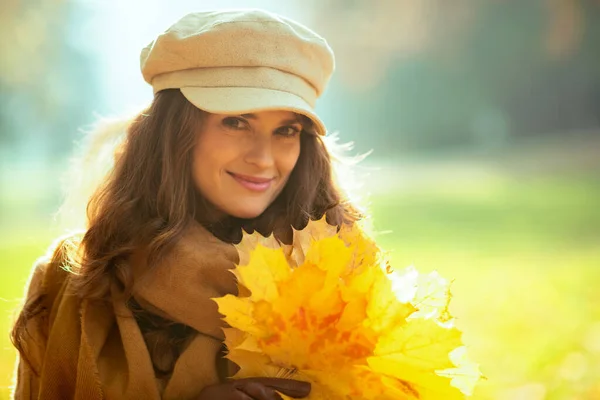 Szczęśliwa nowoczesna kobieta z żółtymi liśćmi na zewnątrz w jesiennym parku — Zdjęcie stockowe