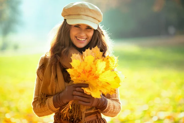 Mulher elegante feliz com folhas amarelas ao ar livre no parque de outono — Fotografia de Stock