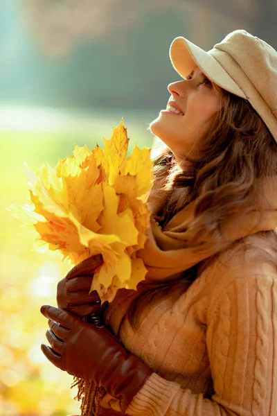 Γυναίκα με κίτρινα φύλλα κοιτάζει έξω στο πάρκο φθινόπωρο — Φωτογραφία Αρχείου