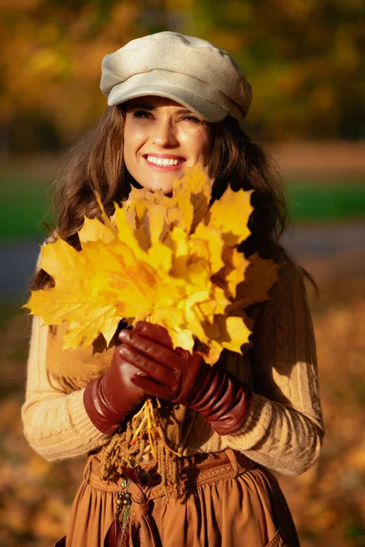 Ευτυχισμένη μοντέρνα γυναίκα με κίτρινα φύλλα σε εξωτερικούς χώρους το φθινόπωρο πάρκο — Φωτογραφία Αρχείου