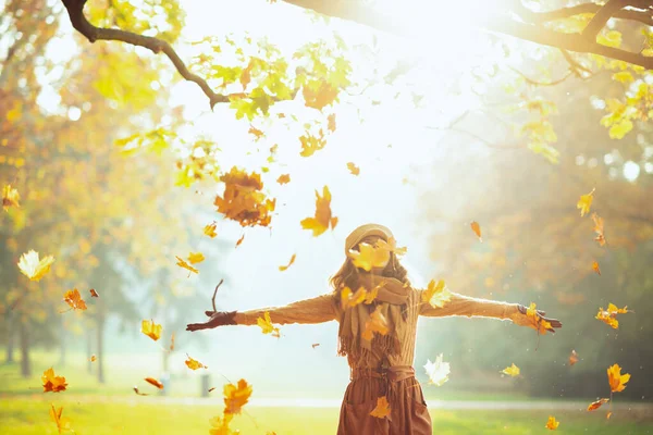 Frau genießt den Herbst und fängt herabfallende gelbe Blätter — Stockfoto