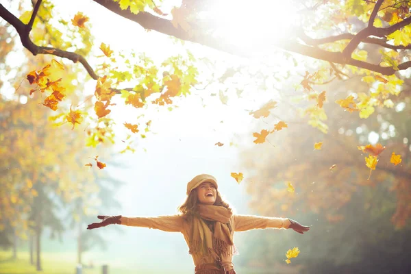 Vrouw genieten van de herfst en vangen vallende gele bladeren — Stockfoto