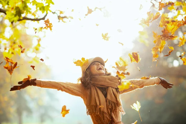 Mujer disfrutando de otoño y la captura de hojas amarillas cayendo — Foto de Stock