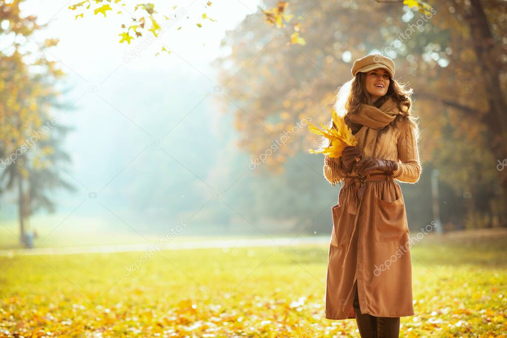 smiling woman with yellow leaves outdoors in autumn park