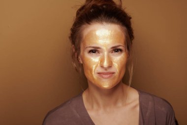 bronz arka planda altın maskeli modern kadın