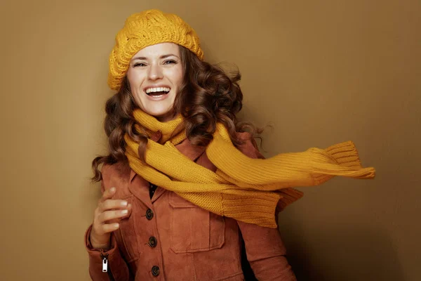 Uśmiechnięta modna kobieta na brązowym tle — Zdjęcie stockowe