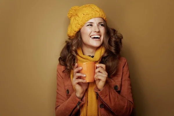 Mulher com xícara de latte de abóbora isolado em fundo marrom — Fotografia de Stock