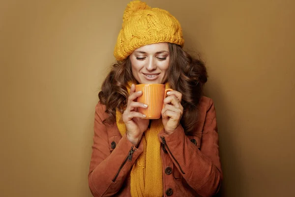 Mujer relajada con taza de té aislado sobre fondo marrón —  Fotos de Stock