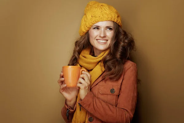 Mujer de 40 años con taza de capuchino aislado en beige — Foto de Stock