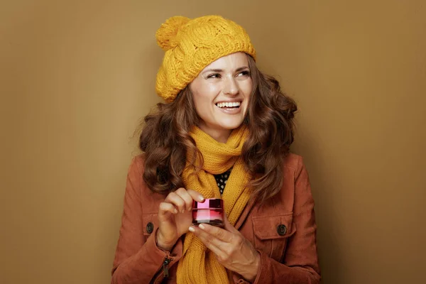 Mujer sonriente con tarro de crema facial mirando espacio de copia — Foto de Stock