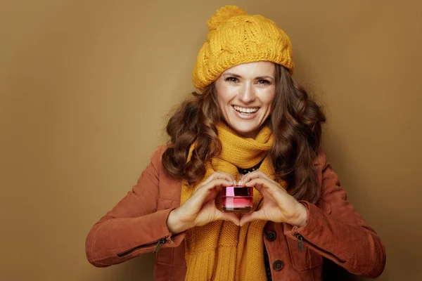 Mujer mostrando frasco de crema facial con las manos en forma de corazón —  Fotos de Stock