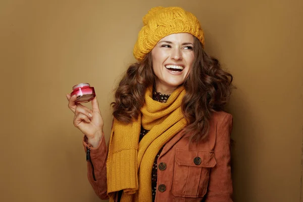 Femme souriante avec pot de crème faciale en regardant l'espace de copie — Photo