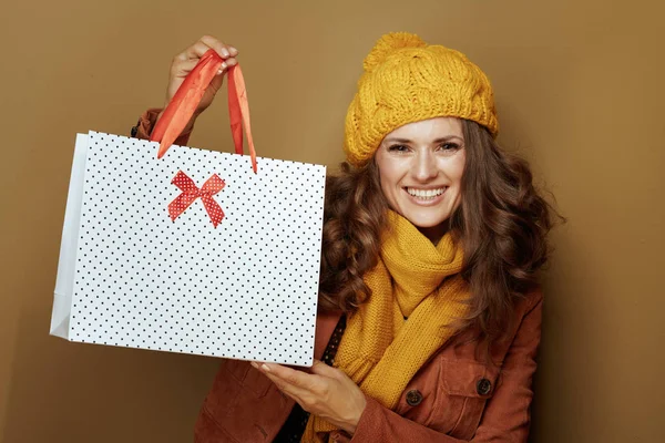 Bronz arka planda izole edilmiş alışveriş torbaları gösteren kadın — Stok fotoğraf