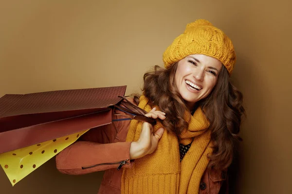 Mujer de 40 años con bolsas de compras sobre fondo beige — Foto de Stock