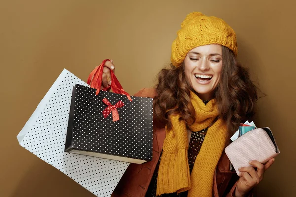 Frau mit Kreditkartengeldbörse und Einkaufstasche isoliert auf beige — Stockfoto