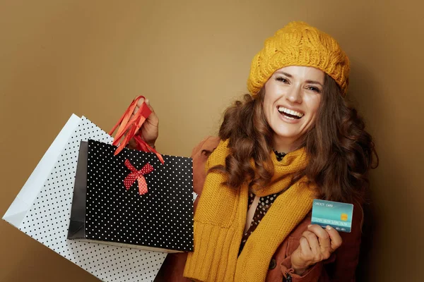 Mujer con tarjeta de crédito y bolsas de compras contra fondo beige —  Fotos de Stock