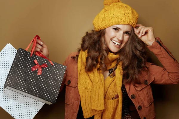 Mujer joven feliz con bolsas de compras sobre fondo beige —  Fotos de Stock