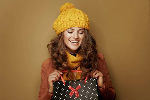 Glückliche Frau mit schwarz gepunkteter Einkaufstasche auf braunem Hintergrund — Stockfoto
