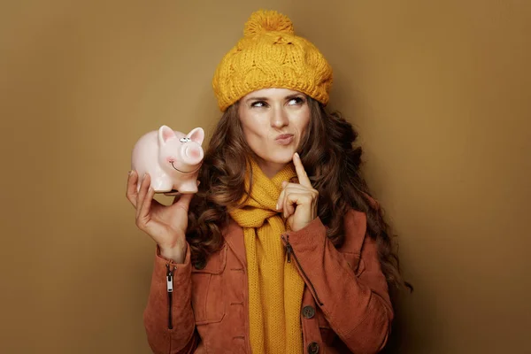 Pensive modern woman with piggy bank looking at copy space — Stock Photo, Image