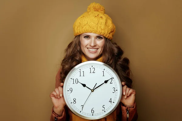 Woman showing round clock remind about autumn time change — Stock Photo, Image