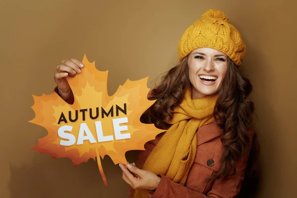 Vrouw tonen herfst verkoop banner tegen bronzen achtergrond — Stockfoto