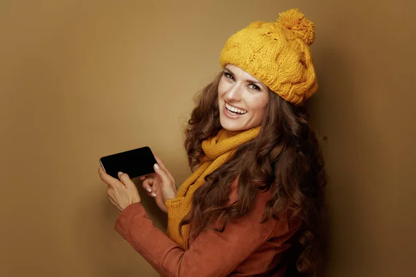 快乐优雅的女人在米色背景下使用智能手机 — 图库照片