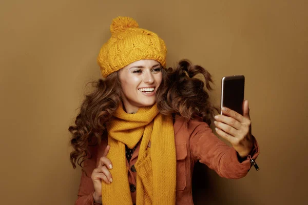 Mulher feliz tomando selfie com telefone e isolado no bege — Fotografia de Stock