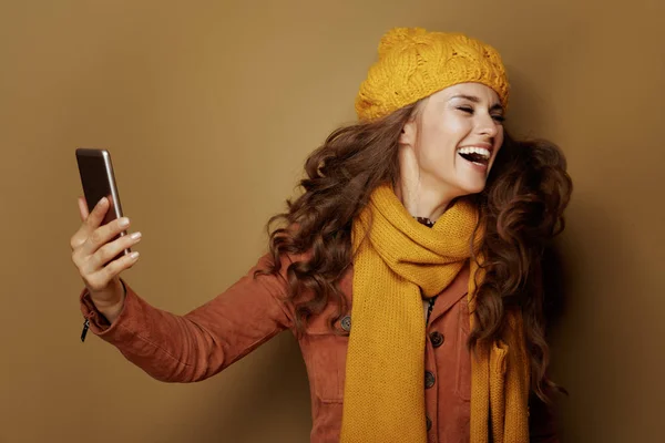 Mulher tomando selfie com telefone e isolado em fundo bege — Fotografia de Stock