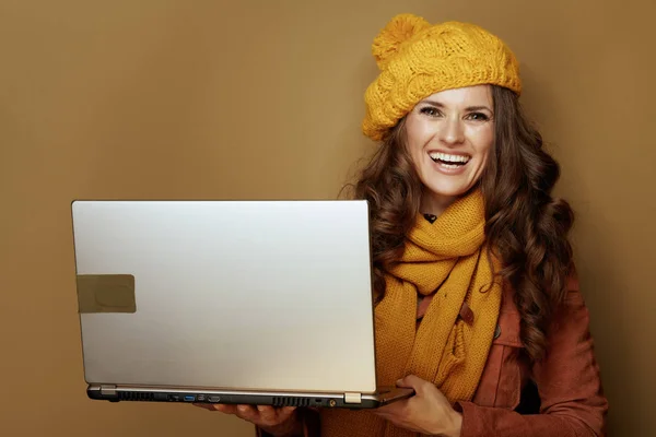 Sorrindo mulher na moda usando o site e contra fundo bege — Fotografia de Stock