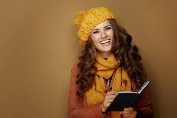 Mujer escribiendo objetivos personales en cuaderno sobre fondo beige —  Fotos de Stock