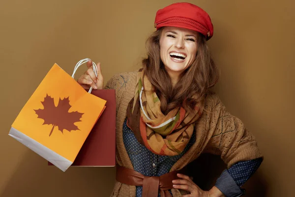 秋のショッピングバッグを見せる幸せなスタイリッシュな中年女性 — ストック写真