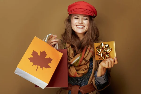 秋の買い物袋と黄金のギフトカードを持つ40歳の女性 — ストック写真