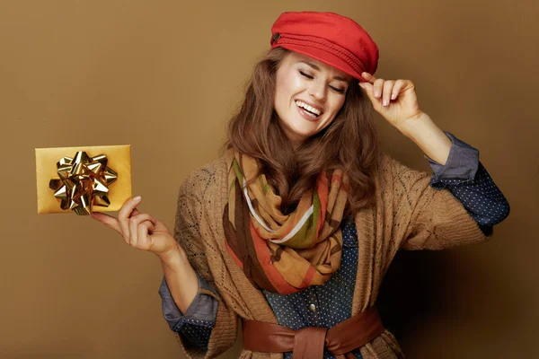 Mujer de 40 años con tarjeta de regalo dorada sobre fondo bronce —  Fotos de Stock