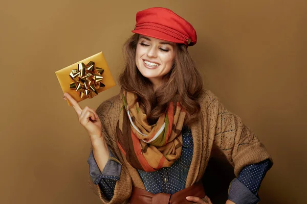 Sonriente mujer moderna de mediana edad mirando la tarjeta de regalo de oro — Foto de Stock