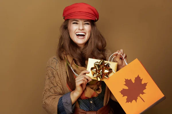 Glimlachende vrouw met herfstboodschappentas en gouden cadeaubon — Stockfoto