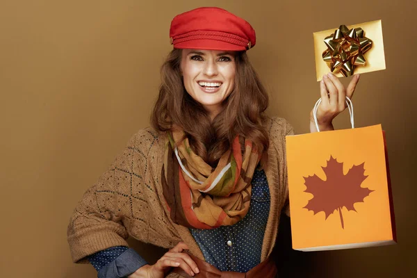 Mujer feliz mostrando el otoño bolsa de compras y tarjeta de regalo de oro — Foto de Stock