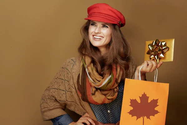 40 letá žena s podzimní nákupní taškou a zlatým dárkovým poukazem — Stock fotografie
