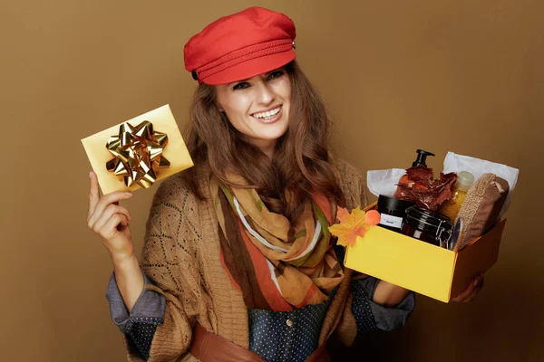 Donna che mostra scatola di cosmetici di bellezza di autunno e carta regalo dorata — Foto Stock