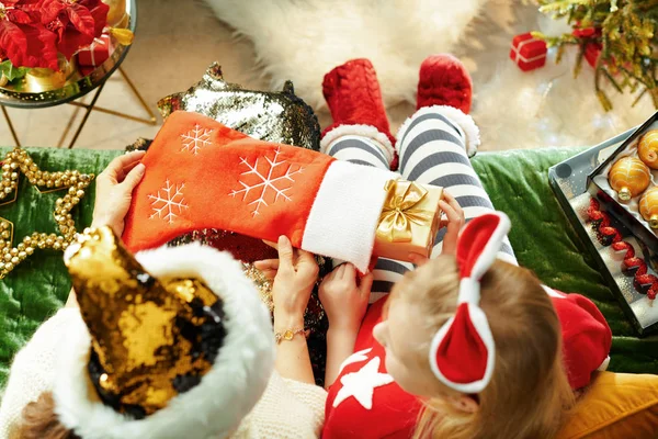 Elegante Mutter und Tochter nehmen Weihnachtsgeschenk aus Socke — Stockfoto