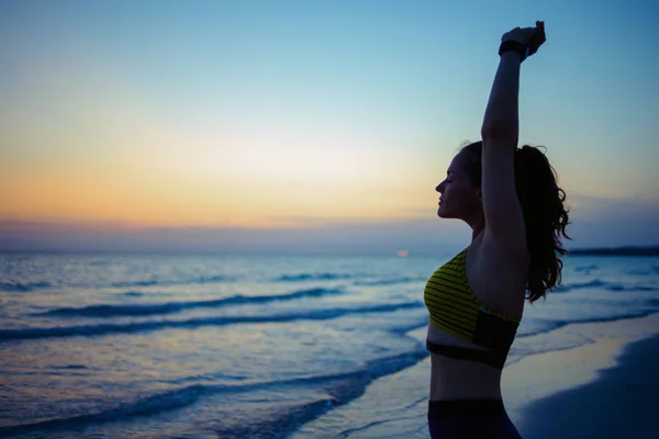 Akşamları Okyanus Kıyısında Spor Elbiseli Genç Bir Kadının Silueti Geriniyor — Stok fotoğraf