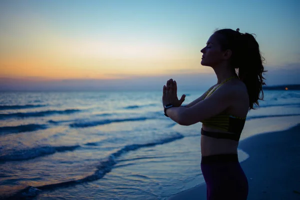 Akşamları Okyanus Kıyısında Meditasyon Yapan Spor Elbiseli Genç Bir Kadının — Stok fotoğraf