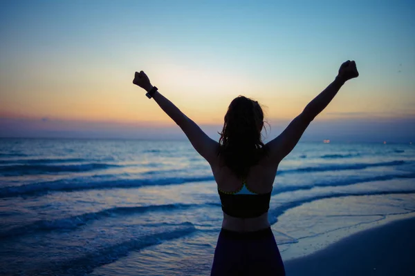 Von Hinten Gesehen Gesunde Sportlerin Fitnesskleidung Strand Beim Abendlichen Jubeln — Stockfoto