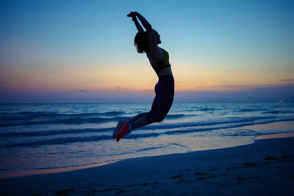 Silhouette Einer Gesunden Frau Fitnesskleidung Abend Beim Hiit Workout Meeresufer — Stockfoto