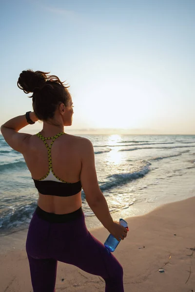 Fitness Frau Sportkleidung Mit Wasserflasche Blickt Abends Der Meeresküste Die — Stockfoto