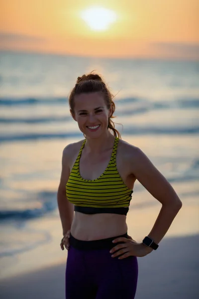 fitness sports woman in sport style clothes on the seashore in the evening relaxing after workout.