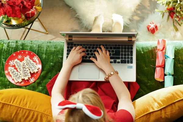 시즌이야 드레스를 소녀가 크리스마스 현대인 거실에 노트북으로 인터넷을 사용하는 — 스톡 사진