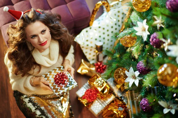 황금색 스커트와 스웨터를 포장된 크리스마스 장식을 있는우아 여성의 — 스톡 사진