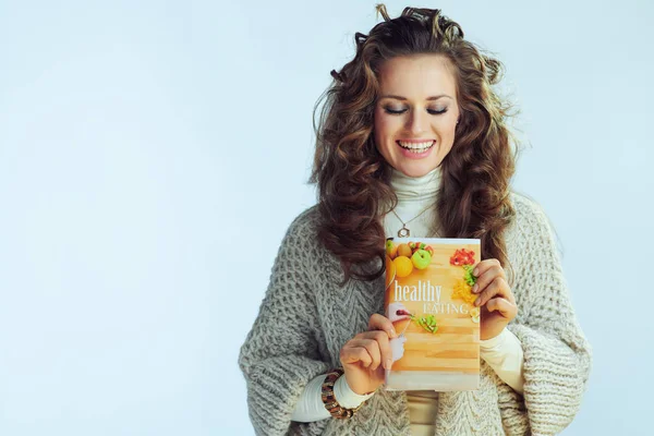 Happy elegant female holding healthy eating book — Stock Photo, Image