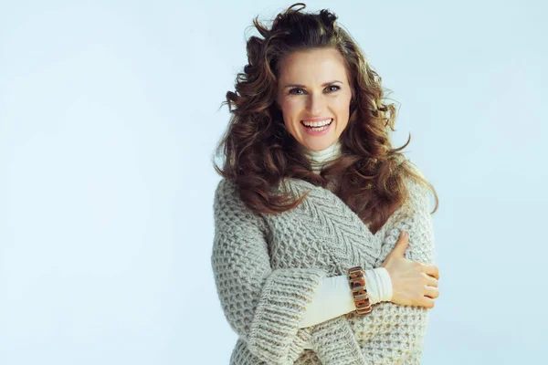 Smiling stylish female against winter light blue background — Stock Photo, Image