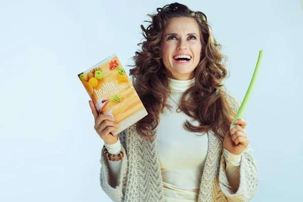 Женщина с книгой здорового питания и глядя вверх на пространство для копирования — стоковое фото